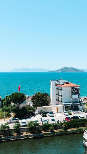 a building with cars parked in a parking lot next to the water at Mia Casa Hotel in Fethiye