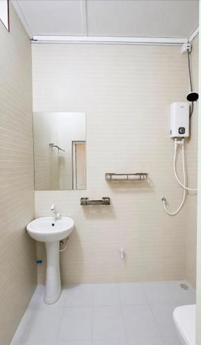 a white bathroom with a sink and a mirror at Stay Kora in Thinadhoo
