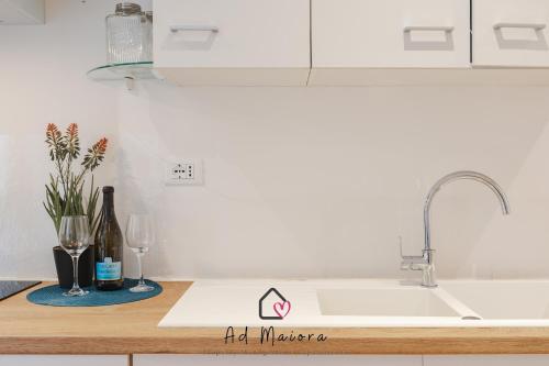 a kitchen counter with a sink and two wine glasses at Il Gioiello di Frieda - in centro a Muggia in Muggia