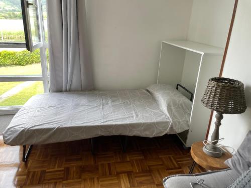 a small bed in a room with a window at Rincon en el Rio Sella in Ribadesella