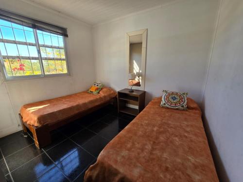 a bedroom with two beds and a mirror and a window at Departamento en San Juan Capital 3 dormitorios hasta 6 personas in San Juan