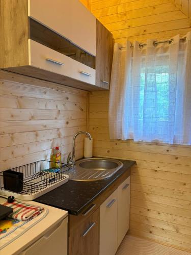 a kitchen with a sink in a wooden cabin at KOMOVI - Dream house - 2 in Andrijevica