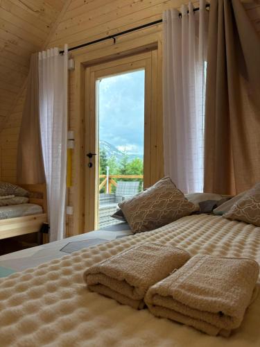 a bedroom with a bed with a large window at KOMOVI - Dream house - 2 in Andrijevica