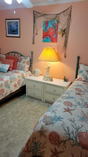 a bedroom with two beds and a table with a lamp at 210 Worcester St #203 OC in Ocean City