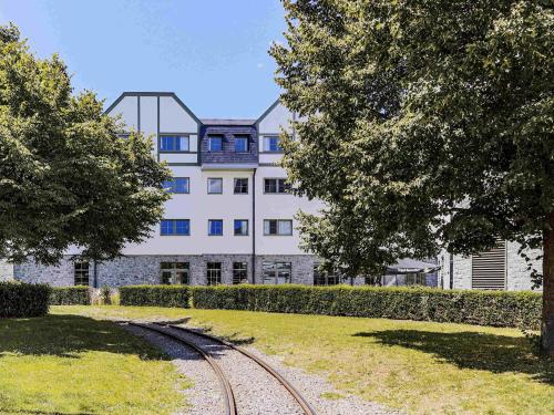 a building with a train track in front of it at Mercure Han-sur-Lesse in Han-sur-Lesse