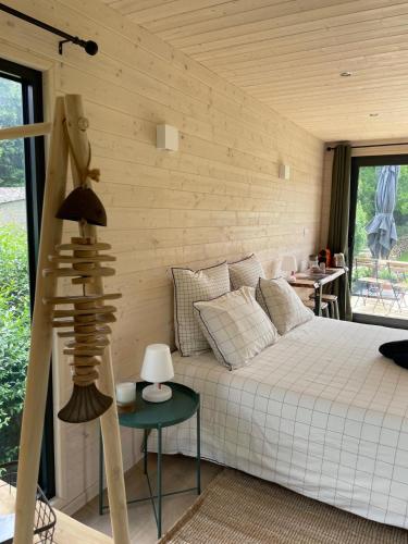 a bedroom with a bed and a wooden wall at Le Lodge de la Course in Beussent