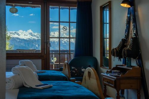 a room with two beds and a window with snow capped mountains at Colorado Riders Chalet in Crans-Montana