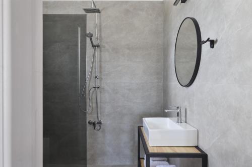 a bathroom with a shower and a sink and a mirror at Pounda Resort Paros, a member of Radisson Individuals in Pounda