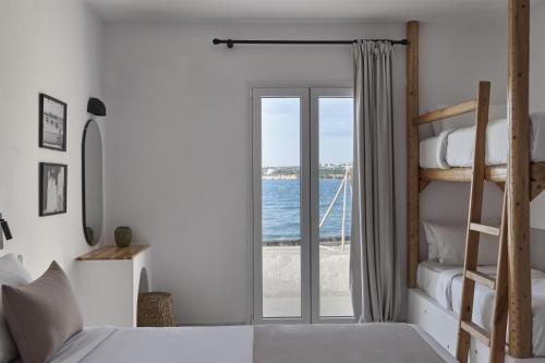 a bedroom with a bunk bed and a view of the ocean at Pounda Resort Paros, a member of Radisson Individuals in Pounda