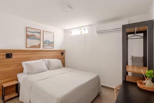 a bedroom with a white bed and a window at Villa Bela - Lofts - cama queen e ar-condicionado in Iguaba Grande