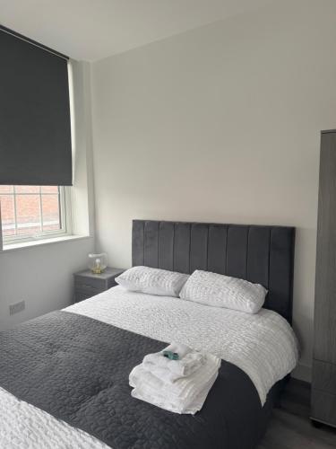 a bedroom with a bed with a towel on it at Stylish modern 2 bedroom flat 6B in Denton