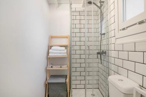 a bathroom with a toilet and a shower with white tiles at Tiny House La Loma in Barbate