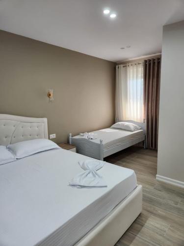 a bedroom with two beds and a window at Lakefront House in Pogradec