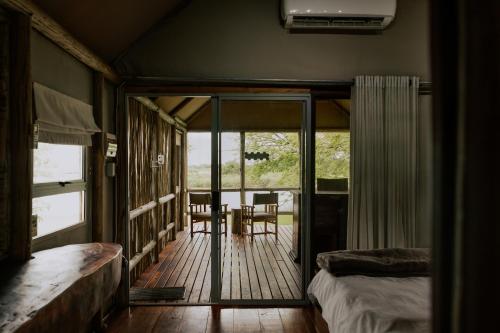 a bedroom with a deck with a table and chairs at Muchenje River Lodge in Katima Mulilo