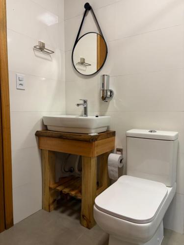 a bathroom with a white toilet and a sink at Cabana Raízes da Mata - Hidro e Natureza in São Joaquim