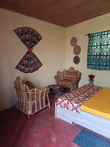 a bedroom with a bed and chairs and a table at Jedd Palace in Kpannou