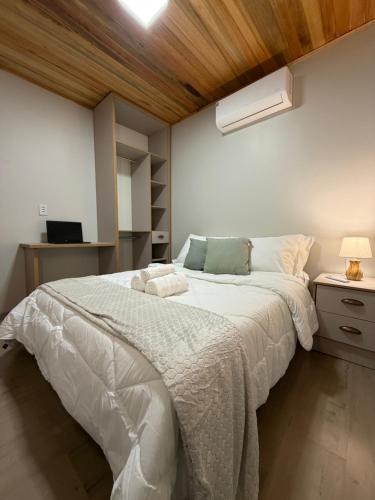 a bedroom with a large bed with a wooden ceiling at Cabana Raízes da Mata - Hidro e Natureza in São Joaquim