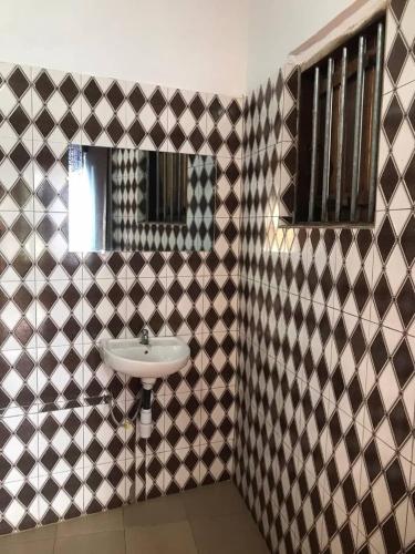 a bathroom with a sink and a mirror at Jedd Palace in Kpannou