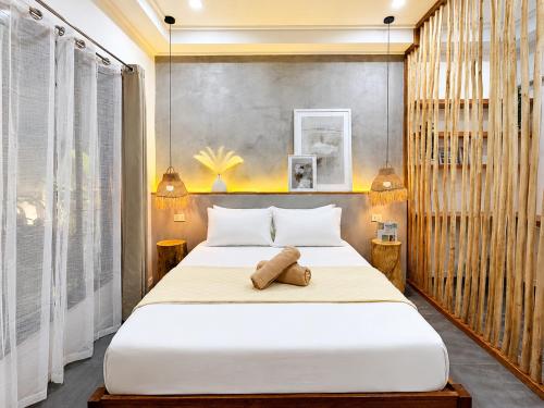 a bedroom with a large white bed with two lamps at White Palm Villa 1 in General Luna