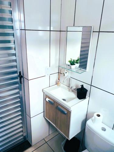 a bathroom with a sink and a mirror and a toilet at kitnet 101 mob in Tatuí