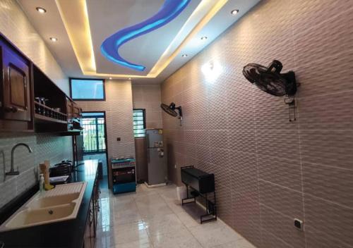a bathroom with a sink and a shower with a blue ceiling at SKYFORCE Bénin - Agatha in Porto-Novo