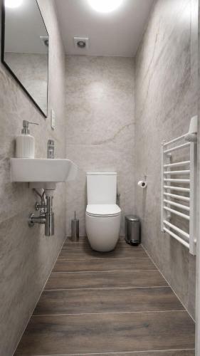 a bathroom with a white toilet and a sink at Hotel Gryf in Gryfice
