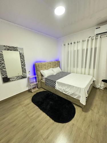 a bedroom with a bed with a black rug at Cintya Maria in Camama