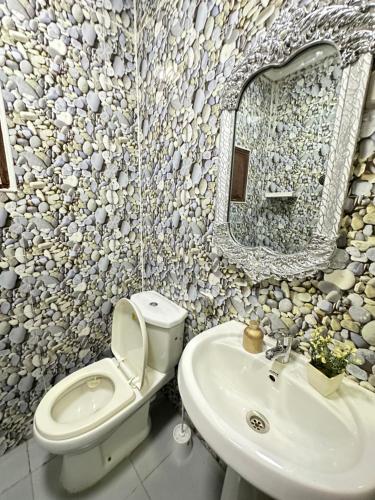 a bathroom with a toilet and a sink and a mirror at Cintya Maria in Camama