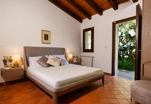 una camera da letto con un letto in una stanza con una finestra di Agrifiumara Villa Sofia a San Francesco di Paola