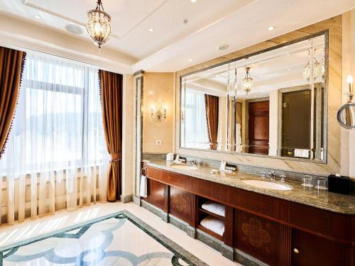 a bathroom with a sink and a large mirror at Fairmont Grand Hotel Kyiv in Kyiv