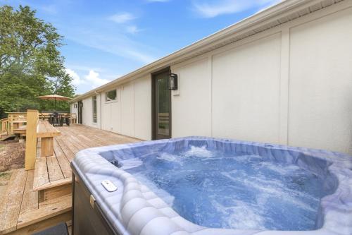 a hot tub on a deck next to a house at Cozy Haven in Three Oaks