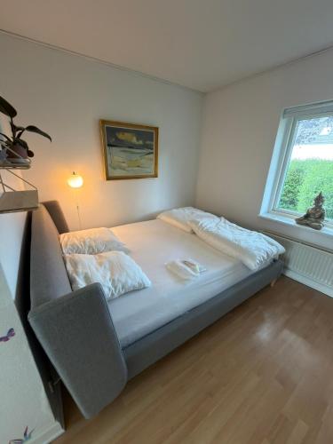 a bed in a room with a window at Sweet Home in Aarhus