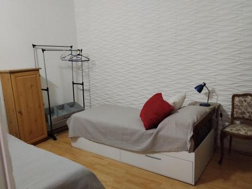 a bedroom with a bed with a red pillow on it at Hostel Familiar Estudiantil in Montevideo