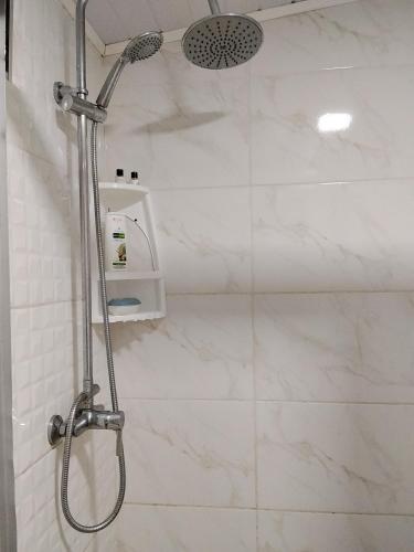a shower in a bathroom with white marble tiles at Hostel Familiar Estudiantil in Montevideo
