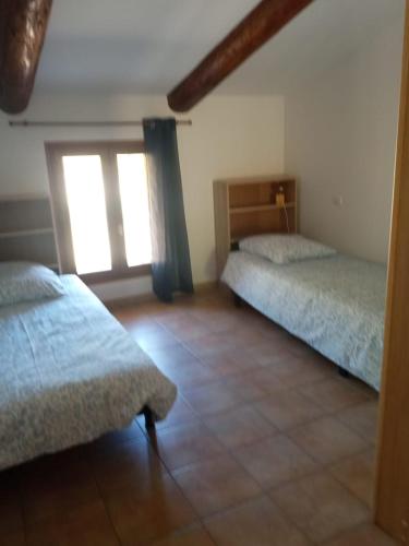 a room with two beds and a window at Le Pied-Redon in Lafare