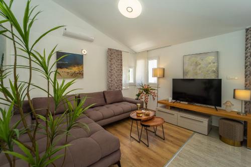 a living room with a couch and a flat screen tv at Villa Green Bay in Vela Luka