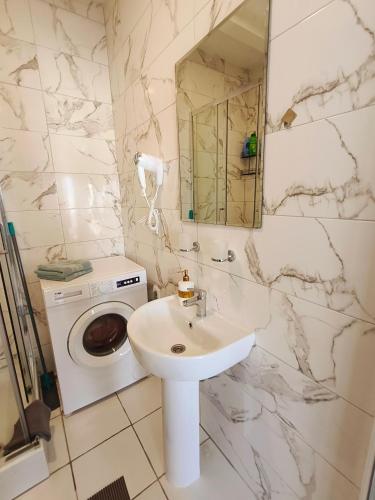 a bathroom with a sink and a washing machine at Good Inn in Bar