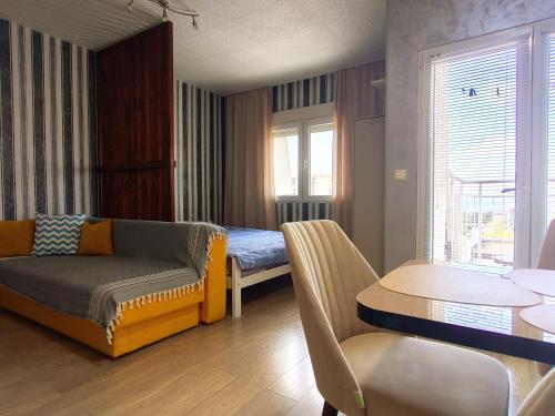 a room with a couch and a bed and a table at Good Inn in Bar
