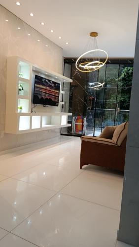 a living room with a couch and a tv at Suíte caripi in Barcarena