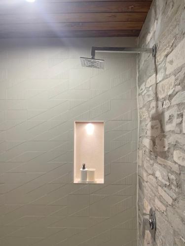 a light in a bathroom with a stone wall at Devshal Eco-Stays in Gupta Kāshi