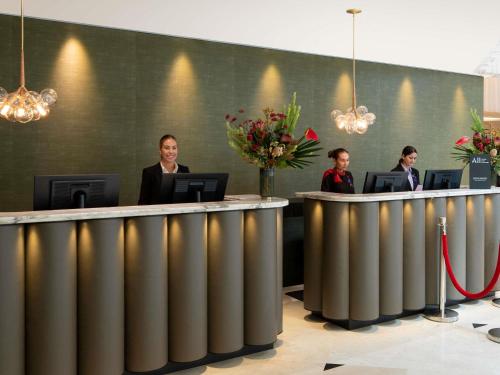 a group of people sitting at a reception desk at Swissotel Sydney in Sydney