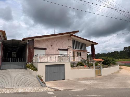 a house with a balcony and a garage at Casa dos Neto Santiago in Anadia
