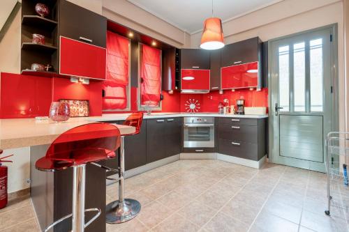 a red kitchen with red cabinets and a counter at Villa Violetta in Nea Anchialos