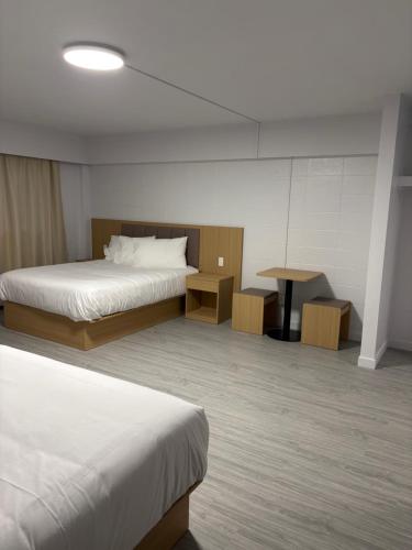 a hotel room with two beds and a table at Rundle Inn and Suites in Edmonton
