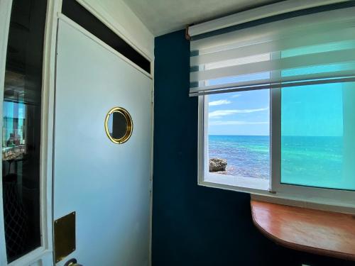 a window with a view of the ocean at "Casitas Arcoiris" Excelente ubicación - Petfriendly in Isla Mujeres