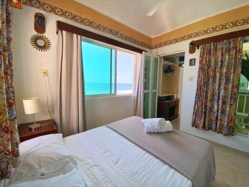 a bedroom with a bed and a large window at "Casitas Arcoiris" Excelente ubicación - Petfriendly in Isla Mujeres