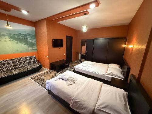 a hotel room with two beds and a tv at Diuma 5 Guest house in Tbilisi City