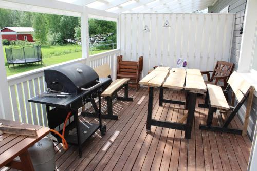 a patio with a grill and tables and chairs at Pikkurinki 27 As 2, Härmä in Härmä