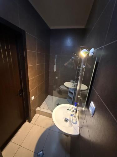 a bathroom with two sinks and a light on the wall at Diuma 5 Guest house in Tbilisi City