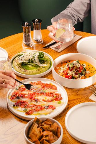 a wooden table with plates of food on it at The Social Hub Madrid 4 star in Madrid